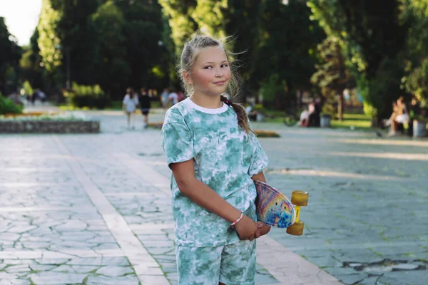 공원에서 스케이트보드를 즐거운 소녀가 귀엽게 휴가를 즐기는 어린이들을 — 스톡 사진
