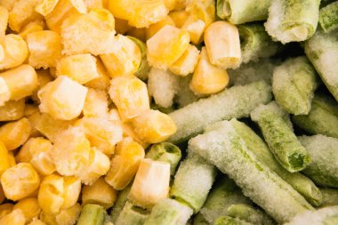 Donmuş kuşkonmaz fasulyeleri ve mısır tanelerini yakın plan, yiyecek arka planı. Gıda hazırlama ve depolama kavramı.