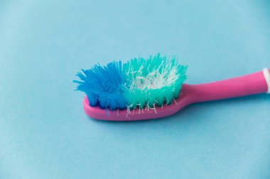 Mavi arkaplanda eski diş fırçası yakın plan.