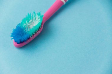 Mavi arkaplanda eski diş fırçası yakın plan.