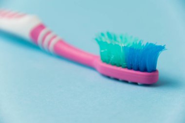 Mavi arkaplanda eski diş fırçası yakın plan.