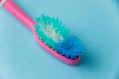 Mavi arkaplanda eski diş fırçası yakın plan.