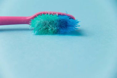 Mavi arkaplanda eski diş fırçası yakın plan.