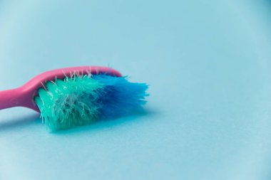 Mavi arkaplanda eski diş fırçası yakın plan.