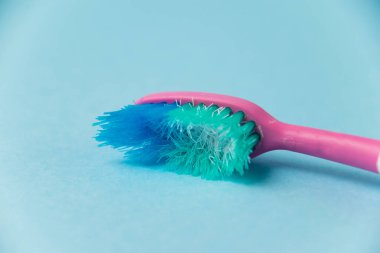 Mavi kağıt arkaplanda eski diş fırçası yakın plan.