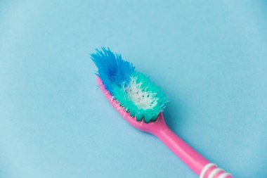 Mavi kağıt arkaplanda eski diş fırçası yakın plan.
