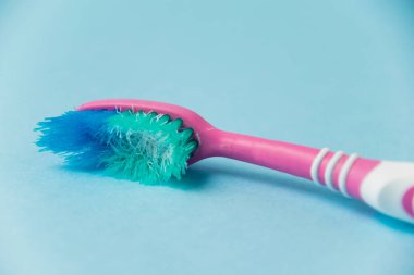 Mavi kağıt arkaplanda eski diş fırçası yakın plan.