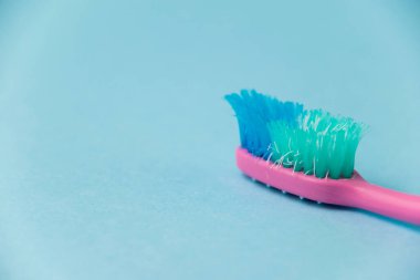 Mavi kağıt arkaplanda eski diş fırçası yakın plan.