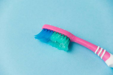 Mavi kağıt arkaplanda eski diş fırçası yakın plan.