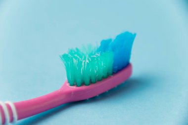 Mavi kağıt arkaplanda eski diş fırçası yakın plan.