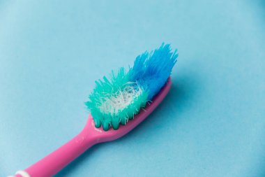 Mavi kağıt arkaplanda eski diş fırçası yakın plan.