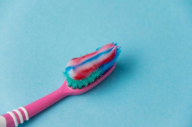 Eski bir diş fırçasında diş macunu. Diş ve sakız bakımı kavramı.