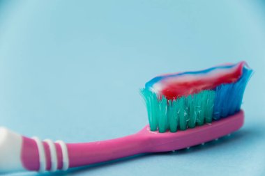 Düzgün diş fırçalama ve oral bakım kavramı. Mavi arka planda diş macunlu eski kullanılmış diş fırçası.