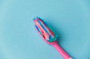 Düzgün diş fırçalama ve oral bakım kavramı. Mavi arka planda diş macunlu eski kullanılmış diş fırçası.