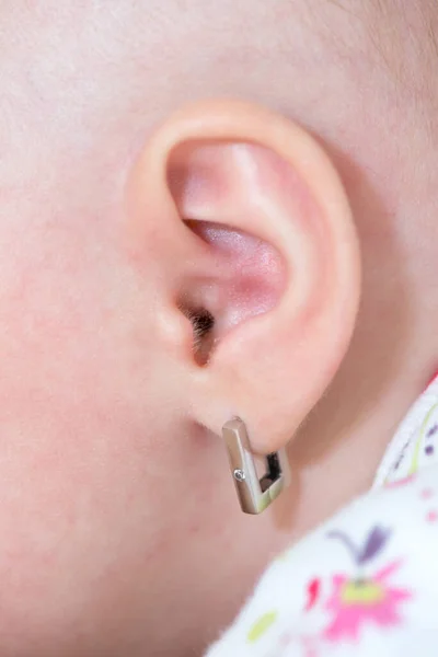 Küpeli bir bebek kulağını kapat.