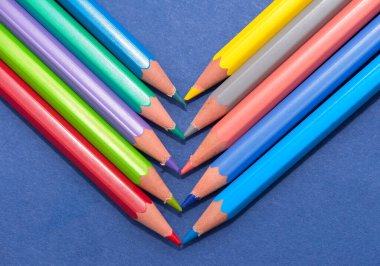 Mavi arka planda boya kalemlerinin düzenlenmesi, stüdyo çekimi.