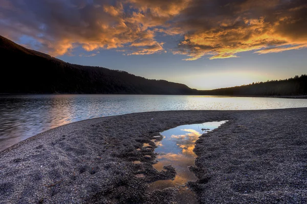Nuvens laranja ao pôr do sol sobre o lago . — Fotografia de Stock