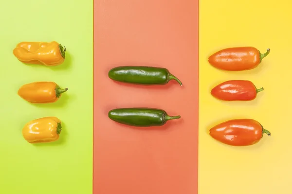 Paprika in Farbgruppen auf lebendigen Hintergründen. — Stockfoto