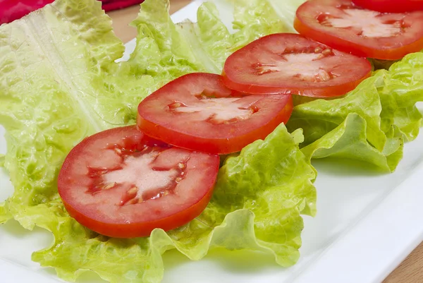 Närbild på skivade tomater och sallad. — Stockfoto