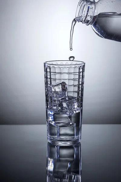 Empezando a verter agua en el vaso . —  Fotos de Stock