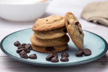 Bir tabak lezzetli çikolatalı kurabiye ve dağınık çikolata parçacıkları yakın. Stüdyoda çekilmiş..