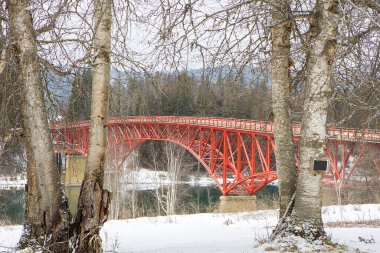 Ione, Washington 'da kışın nehir boyunca uzanan kırmızı köprü..
