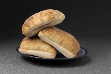 Üç Ciabatta böreğinin küçük bir tabakta çekilmiş bir fotoğrafı..