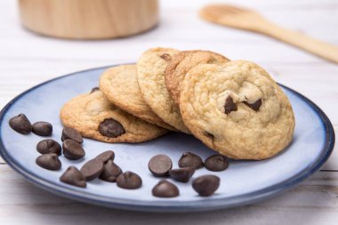 Bir tabak lezzetli çikolatalı kurabiye ve dağınık çikolata parçacıkları yakın. Stüdyoda çekilmiş..