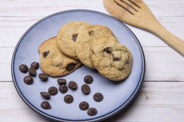 Bir tabak lezzetli çikolatalı kurabiye ve dağınık çikolata parçacıkları yakın. Stüdyoda çekilmiş..