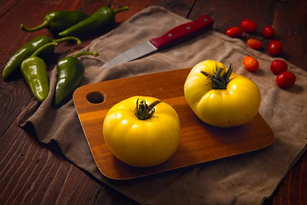 Dos Tomates Amarillos Maduros Una Tabla Cortar Pimientos Verdes Picantes — Foto de Stock