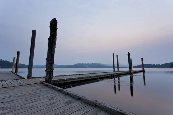 Dock and lake at sunrise. — Stock Photo, Image