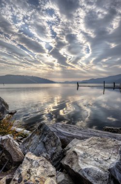 kayalar, göl ve bulutlu gökyüzü.