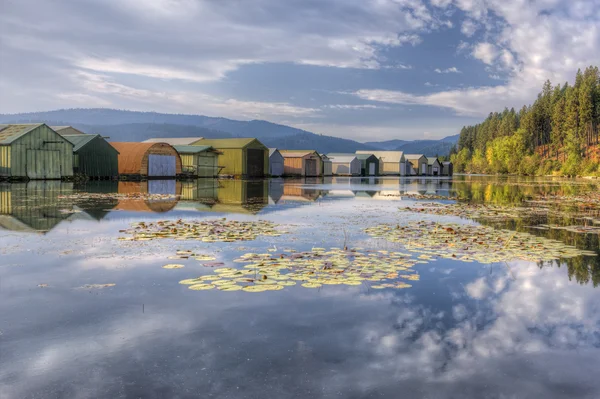 Boat garages on calm lake. — Stock Photo, Image