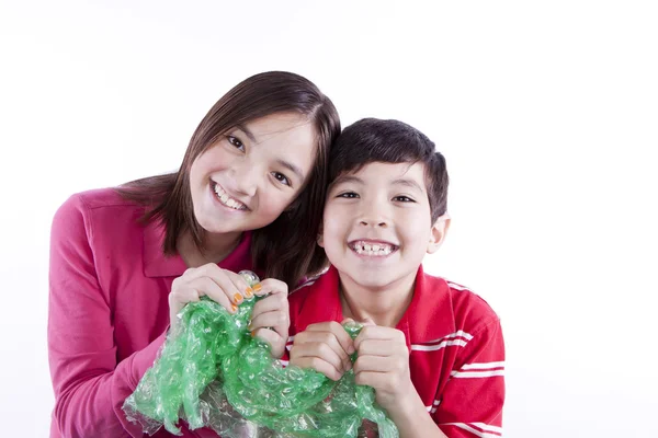 Siblings popping bubble wrap. — Stock Photo, Image