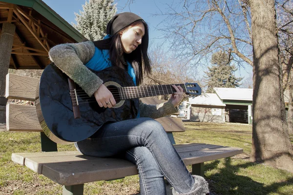 Kobieta na bech gry na gitarze. — Zdjęcie stockowe