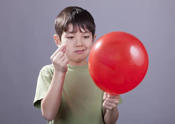 Boy going to pop balloon. — Stock Photo, Image