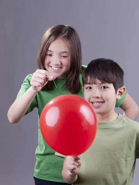 Luftballon ihres Bruders platzen lassen. — Stockfoto