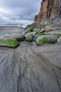 Lines leading to rocks on beach. clipart