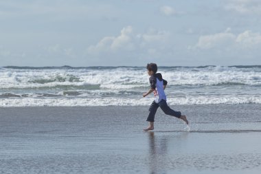 Boy runs in the sand. clipart