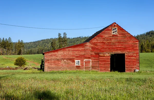 Grange rouge, herbe verte . — Photo