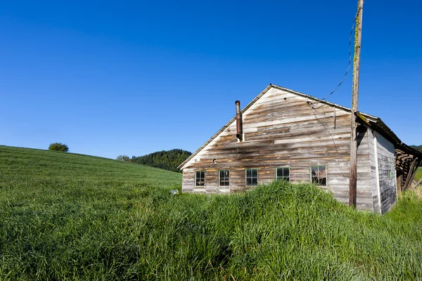 Oude schuur door met gras begroeide heuvel. — Stockfoto