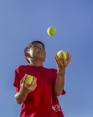 Çocuk tenis topları juggles.