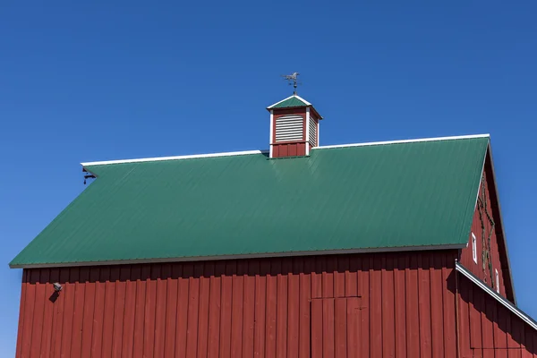 Red barn, green roof, blue sky, — Stock Photo, Image