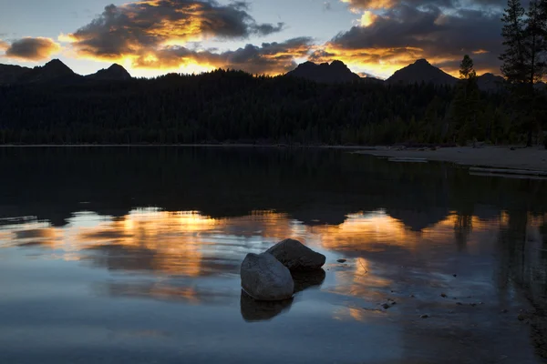 Két sziklák, tó naplementekor. — Stock Fotó