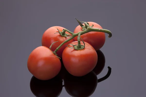 Pomodori su sfondo nero lucido . — Foto Stock