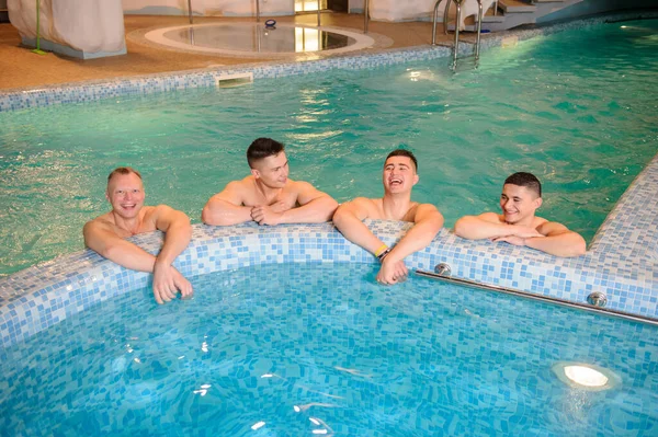 Kaplıcadaki bir yüzme havuzunun tepesinde rahatlayan dört adamın fotoğrafını çek.