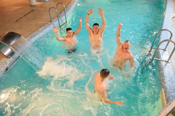 在温泉中心的游泳池里休息的4名男子的头像 — 图库照片