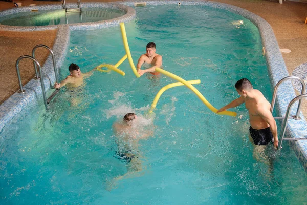 在温泉中心的游泳池里休息的4名男子的近照 — 图库照片