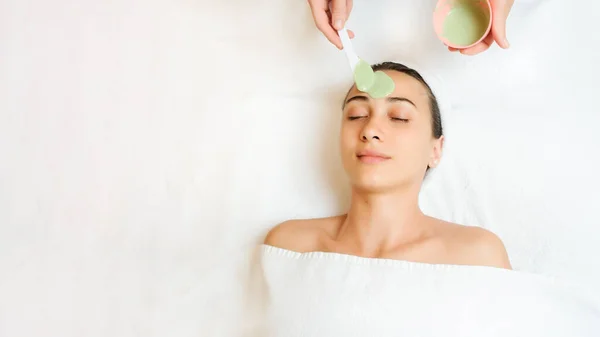 一个戴绿色面具的女人的近照 在皮肤和额头上涂上口罩的治疗师 为您的文本复制空间 — 图库照片