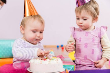 Doğum günü pastasıyla iki bebek.